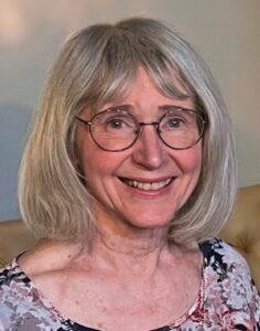 A person with glasses smiling

Description automatically generated